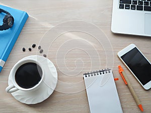 Wood office table with hot black coffee cup, blank screen on not