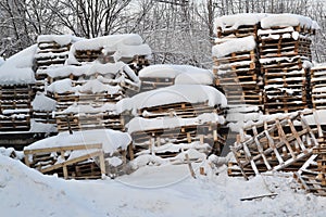 Wood and palets under the snow. Winterfield photo