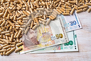 Wood pellets heap and bulgarian lev banknotes close-up. Bio fuel costs, buy and sell pellets. Organic biofuel from compressed