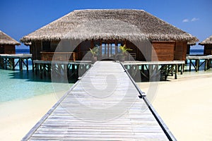 Wood Pier Leading to Overwater Bungalows on Pacific Ocean in the