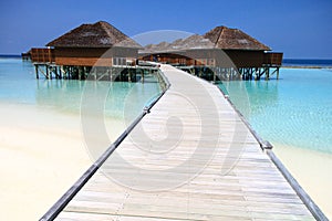 Wood Pier Leading to Overwater Bungalows on Pacific Ocean in the