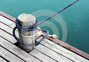 Wood pile with coiled rope on the dock