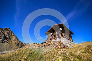 Wood pile in front of cabin and Fagaras mountains