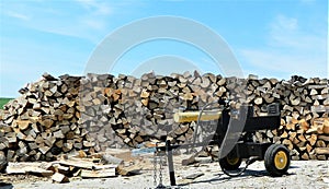 Wood pile with wood splitter in front photo