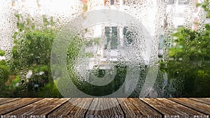 Wood plank with abstract water drop on glass background of glass window shop on a rainy day. Clear, color.