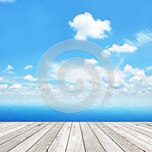 Wood plank as a pier on blue sea & sky background