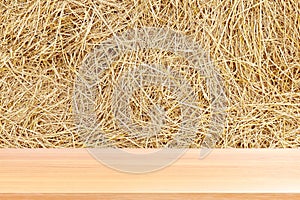 Wood plank on straw, empty wood table floors on straw hay dry background, wood table board empty front straw wall backdrop