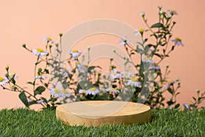Wood podium table top on green grass blurred flower tropical forest plant nature background.Natural product placement pedestal