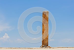 Wood pole for boat rope on blue sky