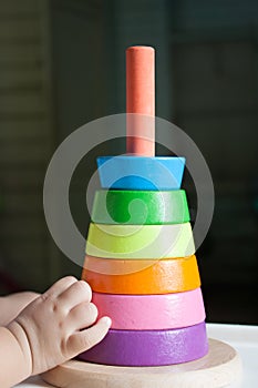 Wood pyramid toy with baby hand