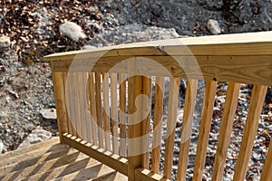 Wood railing going down to a rocky beach in Maine in the springtime
