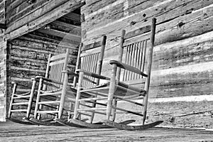 Wood rocking chairs sit idle on a porch