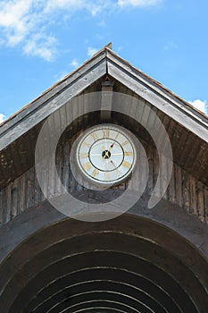 Wood roof arcade with old roman golden numbers clock showing 13:25