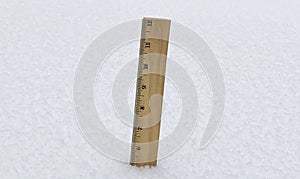 Wood ruler pushed into the snow measuring five inches of snowfall