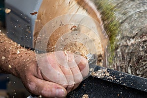 Wood sawdust shavings squirting while creating timber bowl