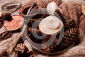 Wood scents for winter time aromatherapy. Pine cones, candles, essential oil bottles, top view. Spa relax winter concept