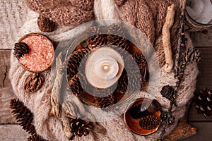 Wood scents for winter time aromatherapy. Pine cones, candles, essential oil bottles, top view. Spa relax winter concept