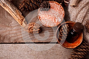 Wood scents for winter time aromatherapy. Pine cones, candles, essential oil bottles, top view. Spa relax winter concept, copy