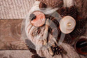 Wood scents for winter time aromatherapy. Pine cones, candles, essential oil bottles, top view. Spa relax winter concept, copy