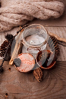 Wood scents for winter time aromatherapy. Pine cones, candles, essential oil bottles, top view. Spa relax winter concept, copy