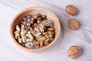 Wood serving spoon with Assortment nuts on wooden table. Close-up.