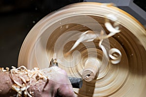 Wood shavings in motion while turnery of a wooden bowl