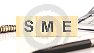 Wood SME on wooden cubes on a white background