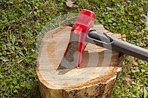 A wood splitting maul on top of a wooden log