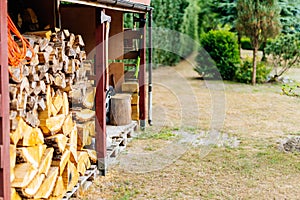 Wood stack with stacked firewood stock for fireplace heating in shed