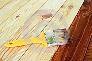 Wood staining. Brush. Painting wooden patio deck with protective varnish