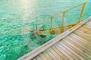 Wood stair into the sea of tropical Maldives island .