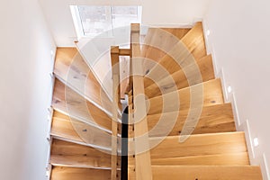Wood staircase inside contemporary white modern house.
