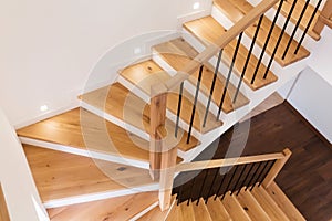 Wood staircase inside contemporary white modern house.