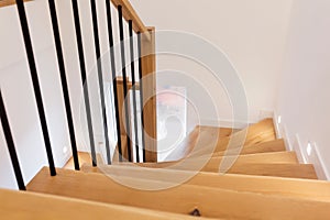 Wood staircase inside contemporary white modern house.