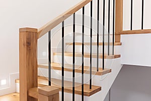 Wood staircase inside contemporary white modern house.