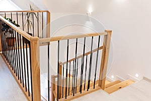 Wood staircase inside contemporary white modern house.