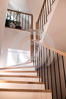 Wood staircase inside contemporary white modern house.