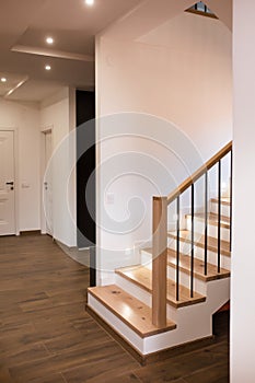 Wood staircase inside contemporary white modern house.