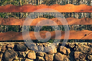 Wood and stone background. wooden fence and natural stone wall in the park