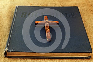 Wood Symbol of Christianity Christian Cross and Vintage Book Holy Bible in English. Concept: Christian religion and traditions