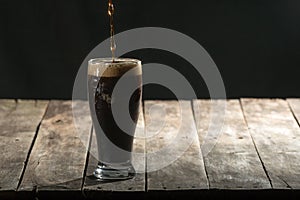 Wood table with black background and craft beer