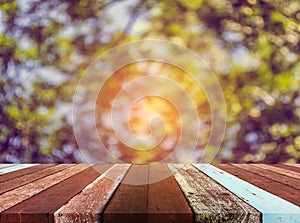 wood table and blur image of green tree . photo