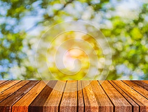 wood table and blur image of green tree . photo