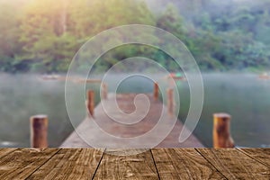 Wood table with blur wood bridge dock lake travel background photo