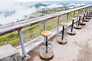 Wood table and chair with their shadow in the early morning. Mountain and the mist is background. Khao kho, Phetchabun, Thailand