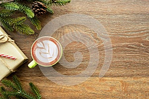Wood table with cup of latte coffee and Christmas decoration with gift box. Christmas and new year celebration concept. Top view