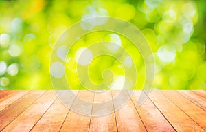 Wood table floor and beautiful natural green leaf abstract blurred bokeh light background