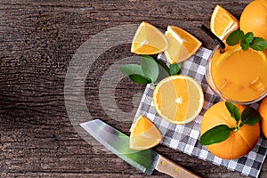 Wood table with fresh sliced orange fruit and glass of orange juice