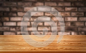 Wood table in front of brick wall blur background.