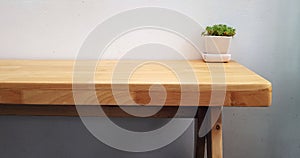 Wood table with green tree on flower pot and cement wall Left co
